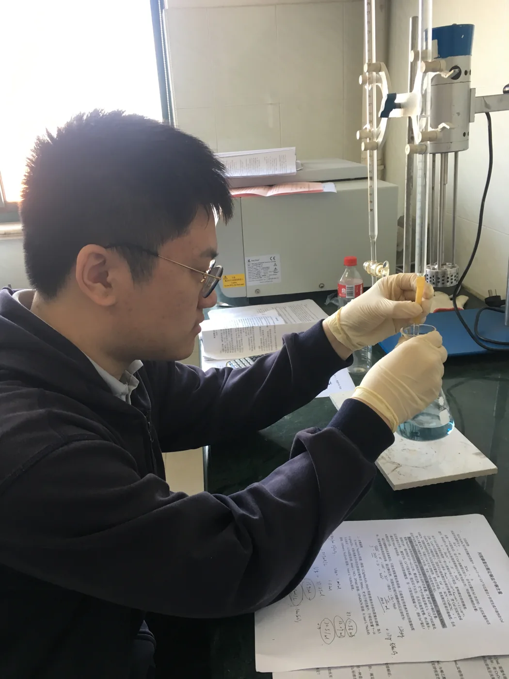 Zijiang carrying out a chemistry experiment at a laboratory bench during high school